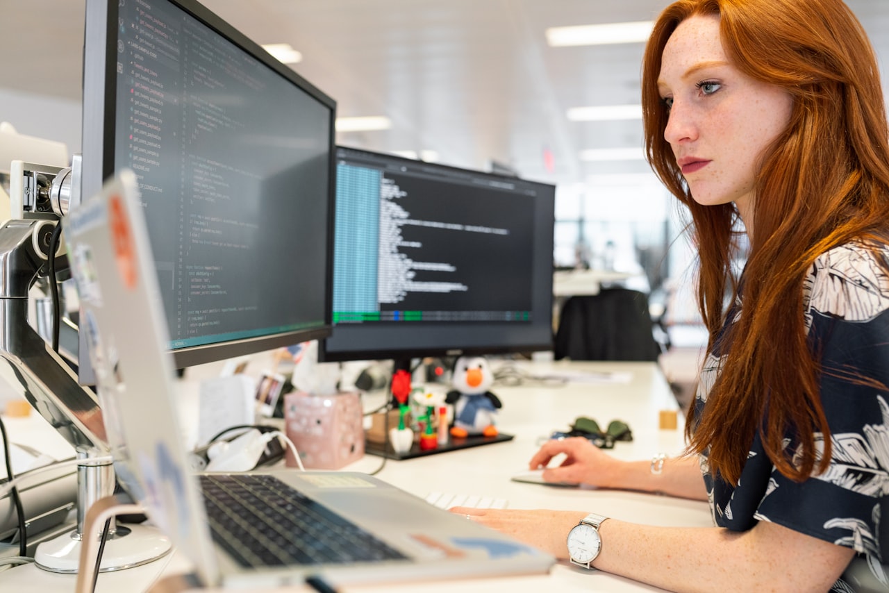 Desenvolvedora programando em múltiplos monitores
